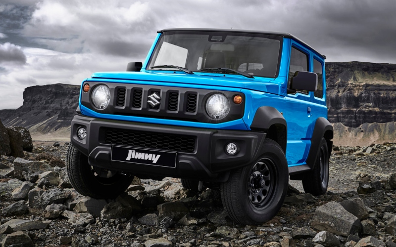 Carro 4x4 Suzuki Jimny azul, modelo de vehÃculo todoterreno compacto, recorriendo un camino rocoso en un entorno natural.